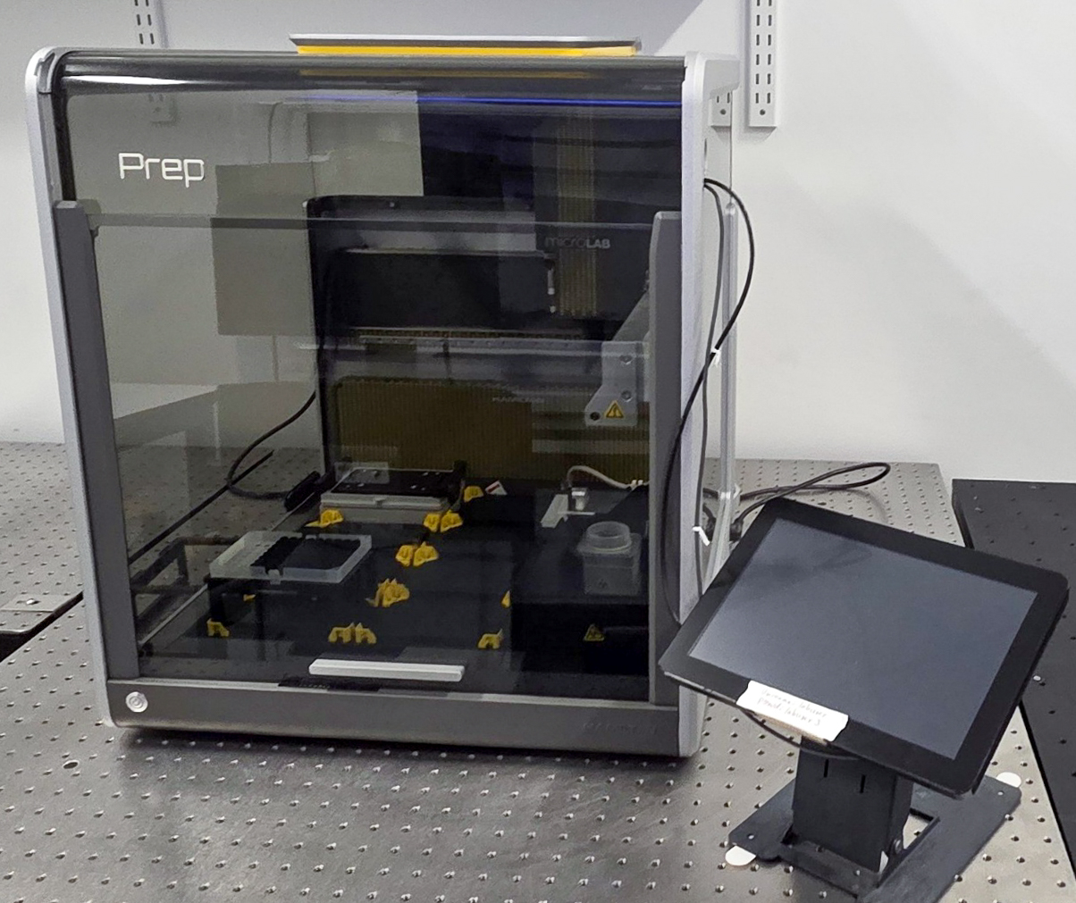 A Hamilton Microlab Prep liquid handler with a transparent front, yellow tips and a touchscreen interface on a stand in a laboratory setting.
